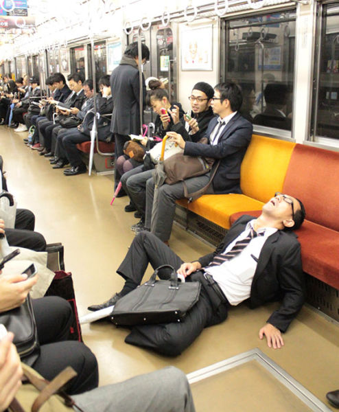 Japán férfi alszik a metrón a földön ülve