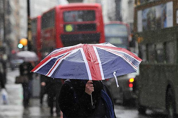 Férfi szakadó esőben Londonban