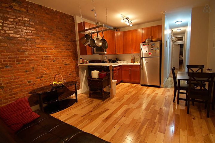 Egy brooklyni lakás kellemes konyhája és nappalija rakott tégla fallal