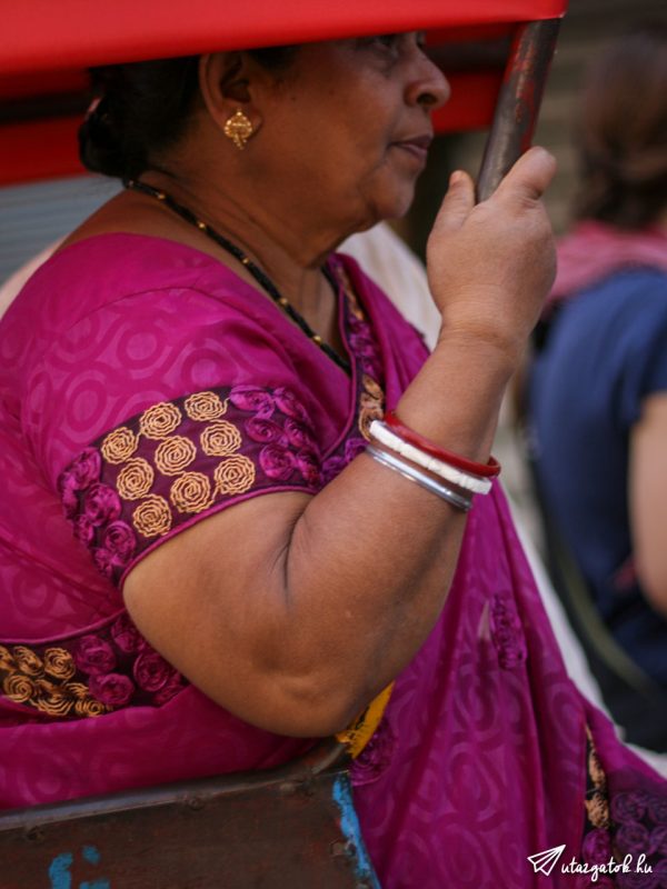 látszólag jómódú indiai asszony utazik tuk-tuk-on