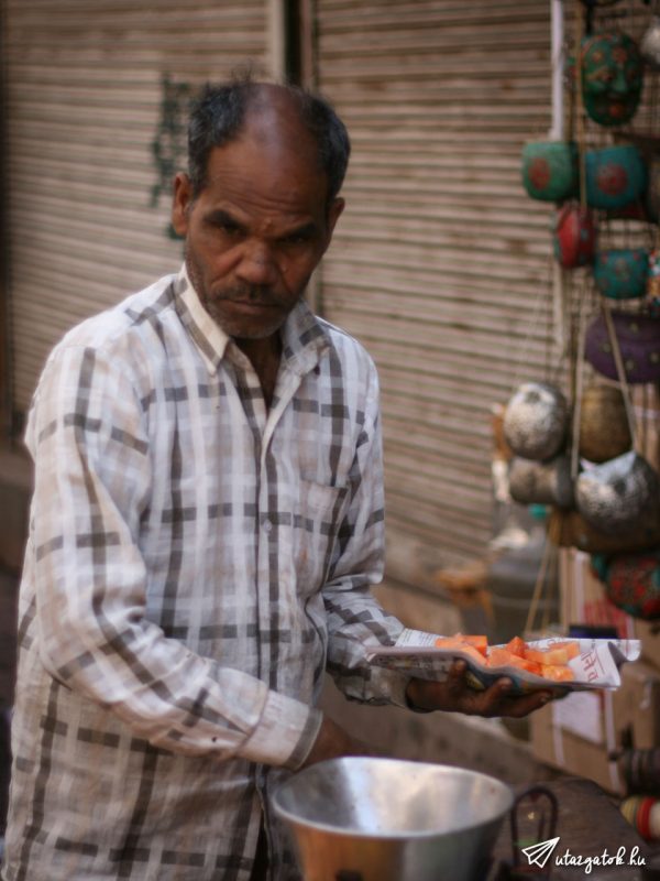 indiai férfi gyümölcsöt szolgál fel kocsijáról