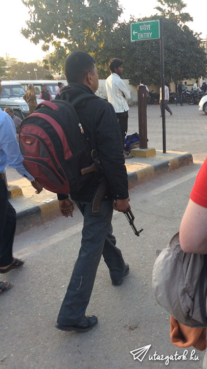 Egy hátizsákos srác Kalashnikov-val a kezében sétál az állomás felé