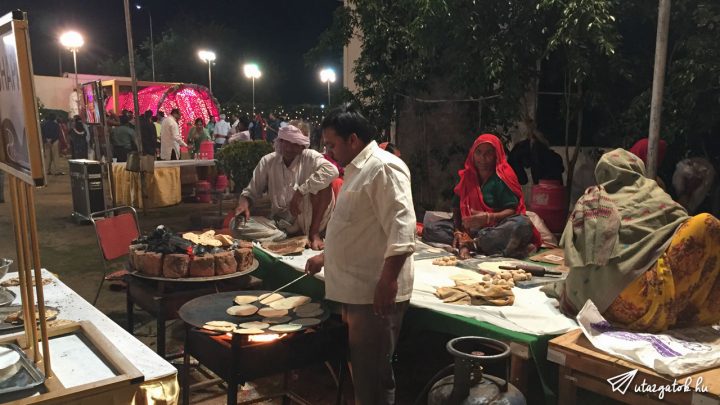 Konyha indiai módra: asszonyok ülnek az asztalon és gyúrják a tésztát, közben a férfiak sütik a lepényeket, mindenki mezítláb