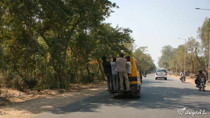 Négy indiai lóg egy mozgó autó hátulján az autópályán