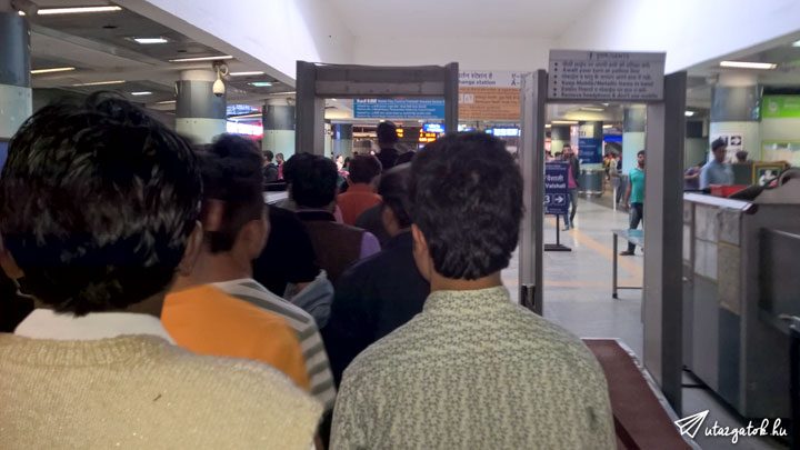 férfiak sorakoznak hogy átlépjenek a fémdetektoros kapun Delhiben