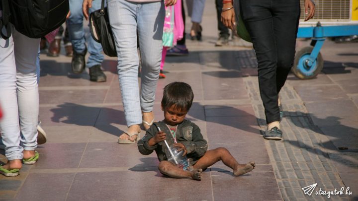 1-2 éves kisfiú játszik a szeméttel az utcán