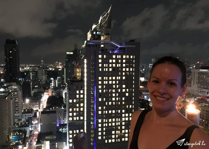Kinga egy felhőkarcoló teteján, háttérben Bangkok éjszakai fényei
