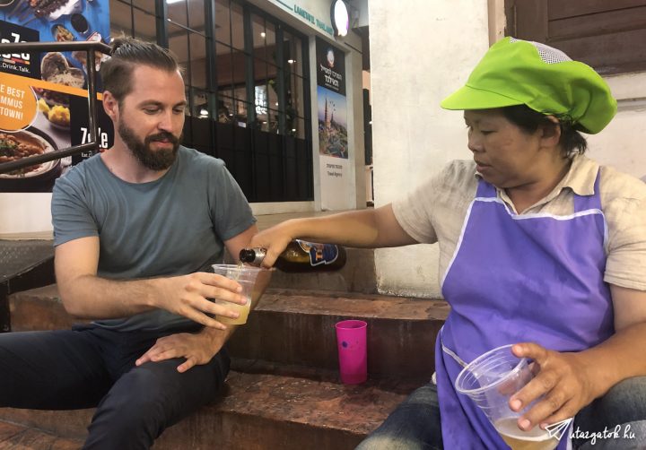 Egy thai asszony tölt nekem sört egy piacon