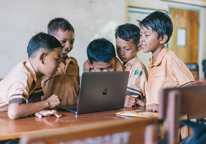 Ázsiai gyerekek körbeállnak egy laptopot